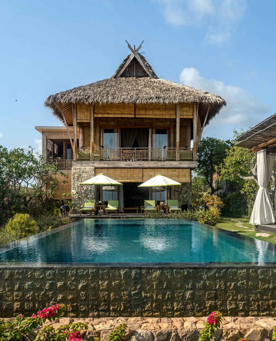 Luxury semi-permanent duplex villa at Nihi Sumba with traditional thatched roof and private pool.