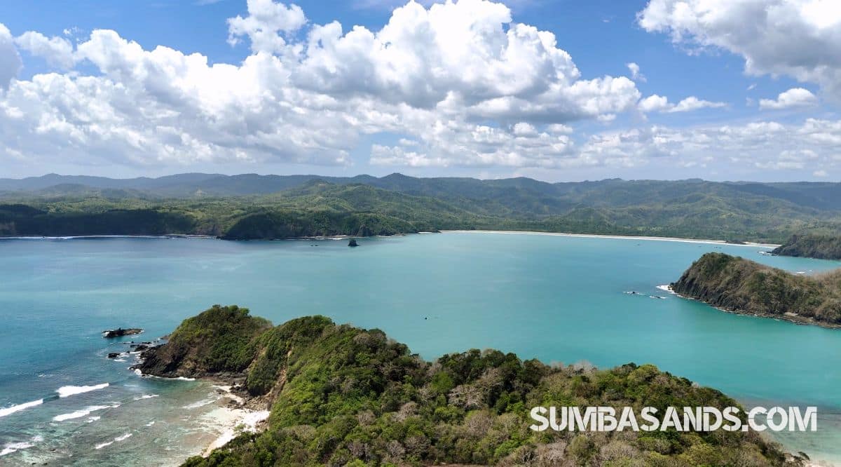 Aerial panorama of a dramatic 23.5-hectare peninsula in Matauki Bay, West Sumba, featuring turquoise waters and rolling green hills
