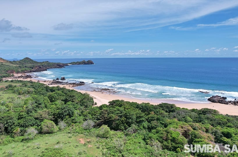 A breathtaking aerial panorama of the 8,000m² Tawui Beach Surf Investment plots. The image captures the wide white-sand shoreline meeting the turquoise Indian Ocean, with rugged cliffs and a serene, untouched coastal landscape.