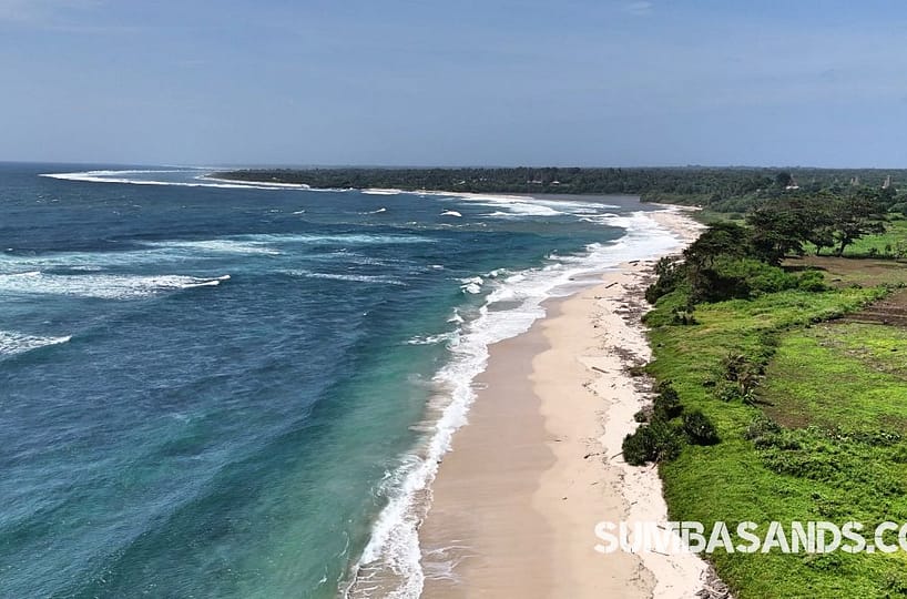 A massive aerial panoramic of the 6.6-hectare Wainyapu Virgin Beachfront Estate. The image captures miles of untouched white sand meeting crystal-clear turquoise waters and vibrant green coastal plains.
