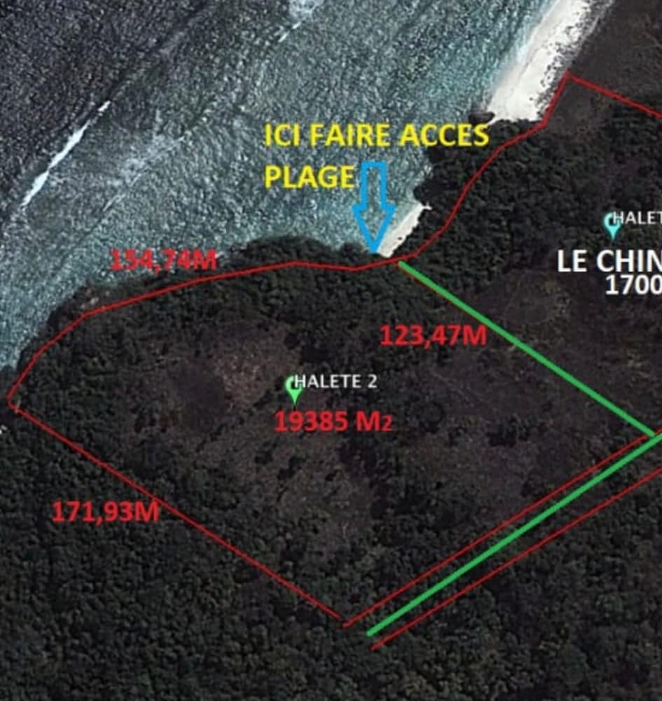 A wide aerial drone photograph capturing the defined yellow boundary line of the 19,385 sqm freehold plot in Mangga Nipi, West Sumba. The image showcases an elevated, grassy coastal cliff plateau dropping down into a rugged rocky cliff face, looking over permanent panoramic ocean views and a massive shallow reef bay.